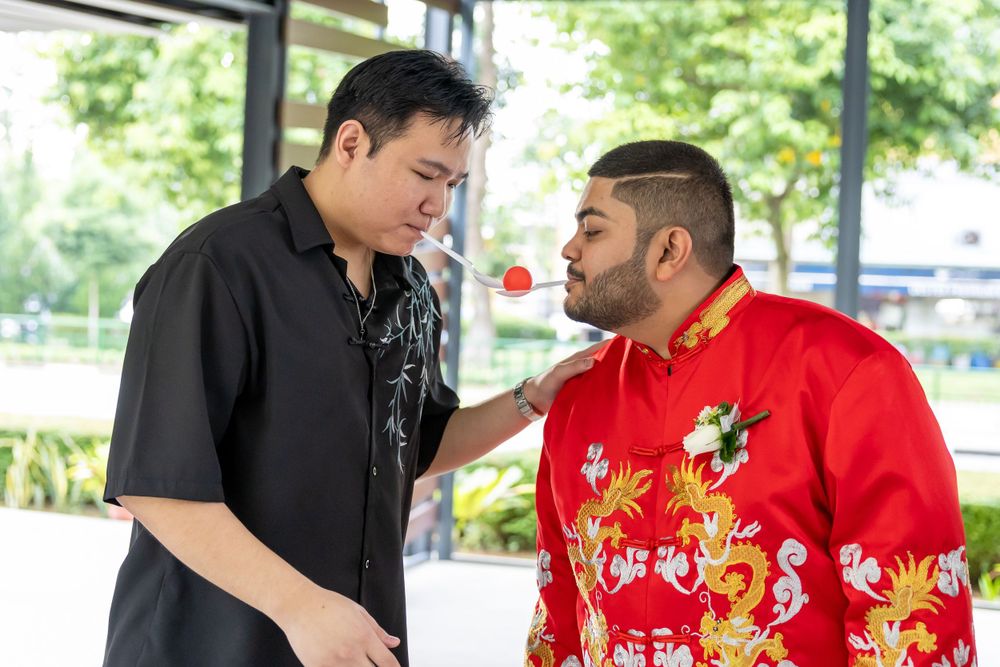 Two people sharing a friendly moment during traditional wedding festivities.