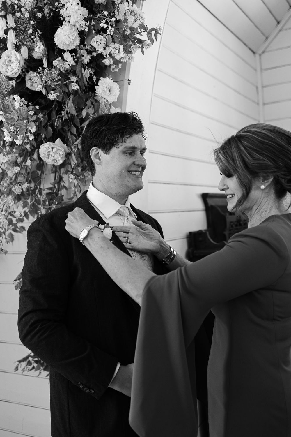 A series of black and white photos showing a joyful moment between a couple in formal attire embracing and smiling.