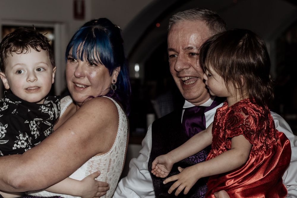 People sharing a joyful moment at what appears to be a wedding celebration or formal event.
