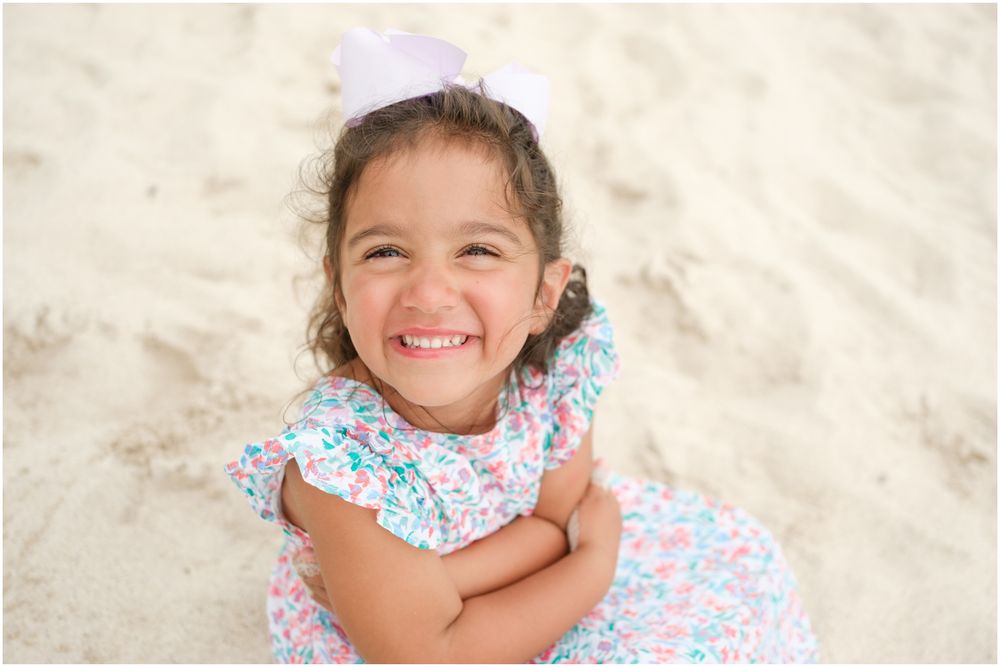 Four Seasons Punta Mita family photography session, children playing and smiling on a sandy beach wearing floral print outfits.
