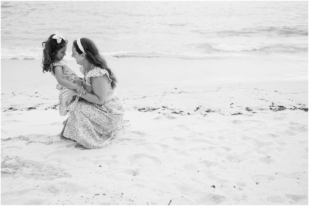 Four Seasons Punta Mita family photography session, black and white beach portrait of two people sitting close together on the sand