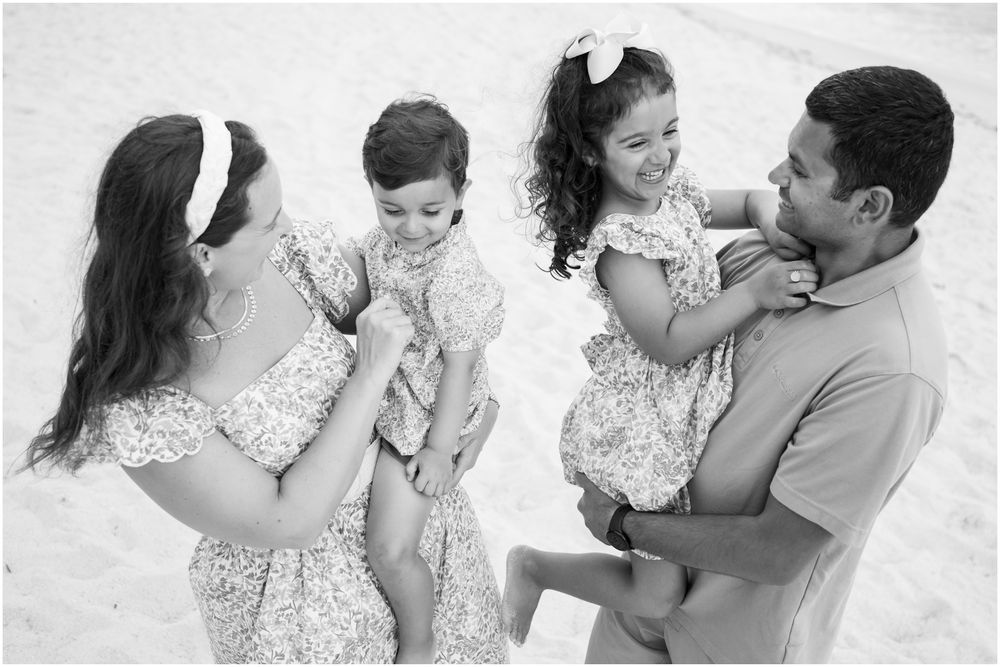 Four Seasons Punta Mita family photography session, joyful family playing on a sunny beach in floral outfits during natural coastal light