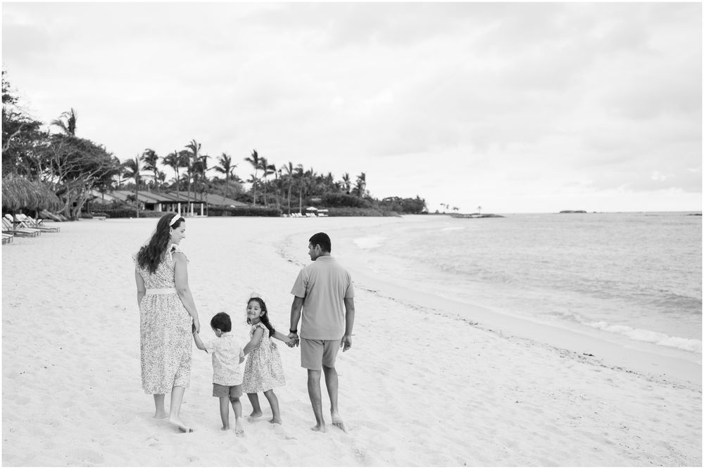 Four Seasons Punta Mita family photography session, family holding hands while walking along a tropical beach.