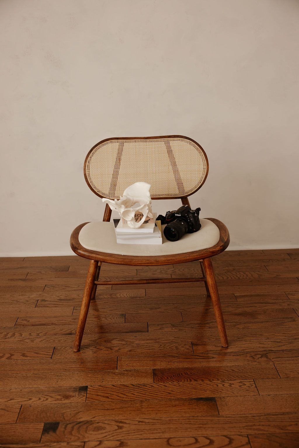 a pelvis model on top of a few doula books with a DSLR camera atop a chair