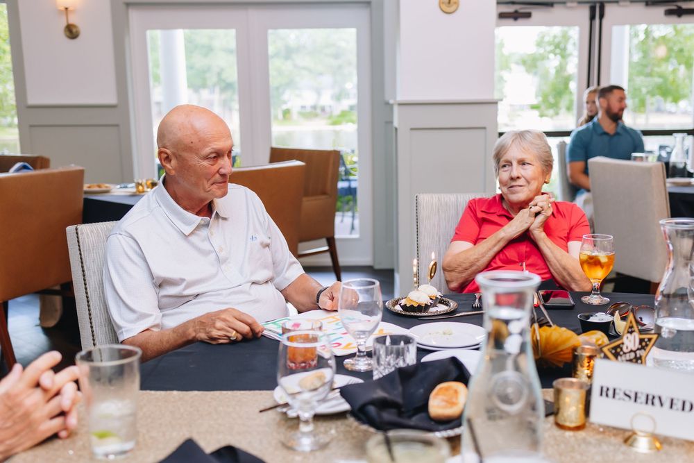 Seniors enjoying a meal together at an upscale dining table in a bright restaurant interior.