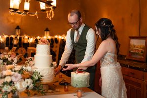 A row of elegant wedding cake displays in warm lighting at a rustic venue during a reception celebration.