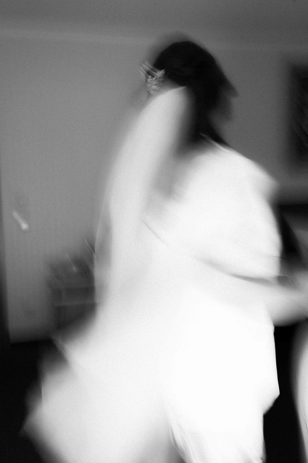Artistic blurred black and white motion photo of figure in white.
