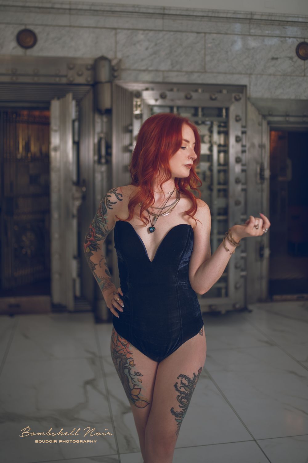 A figure in a black outfit poses dramatically in an industrial space featuring exposed concrete walls and floors.