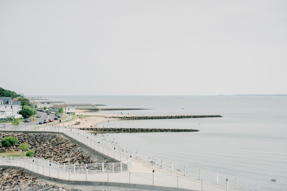 A scenic coastal jetty extends into calm waters with clear skies at Alabama Point East in Orange Beach.