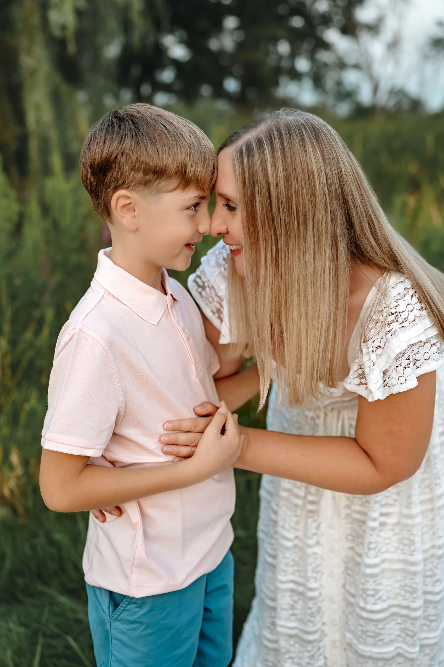 Sweet candid moment capturing tender interaction between two people in pink and white outfits outdoors.