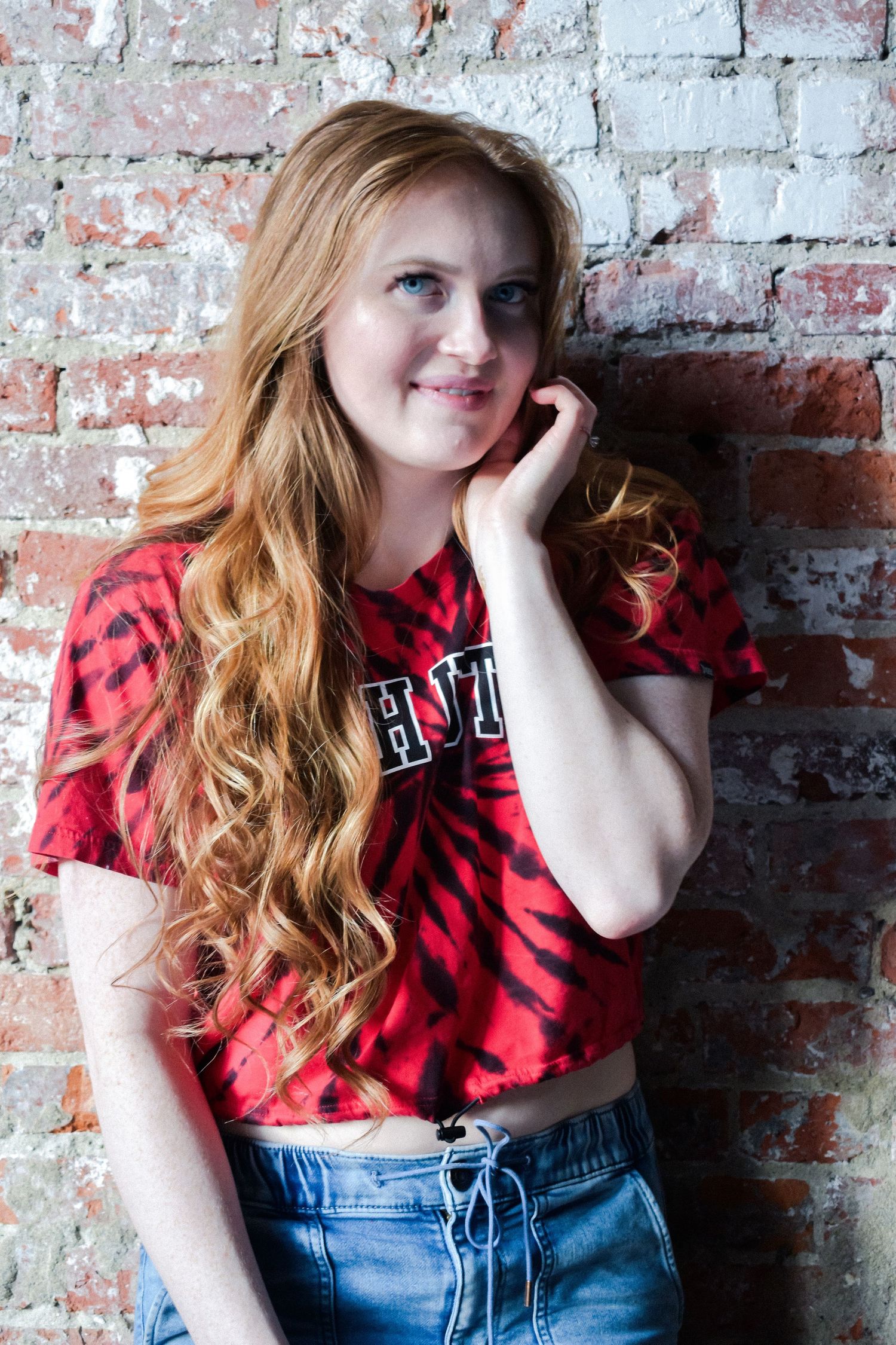 Seattle senior photography session featuring high school student in casual outfit leaning against brick wall