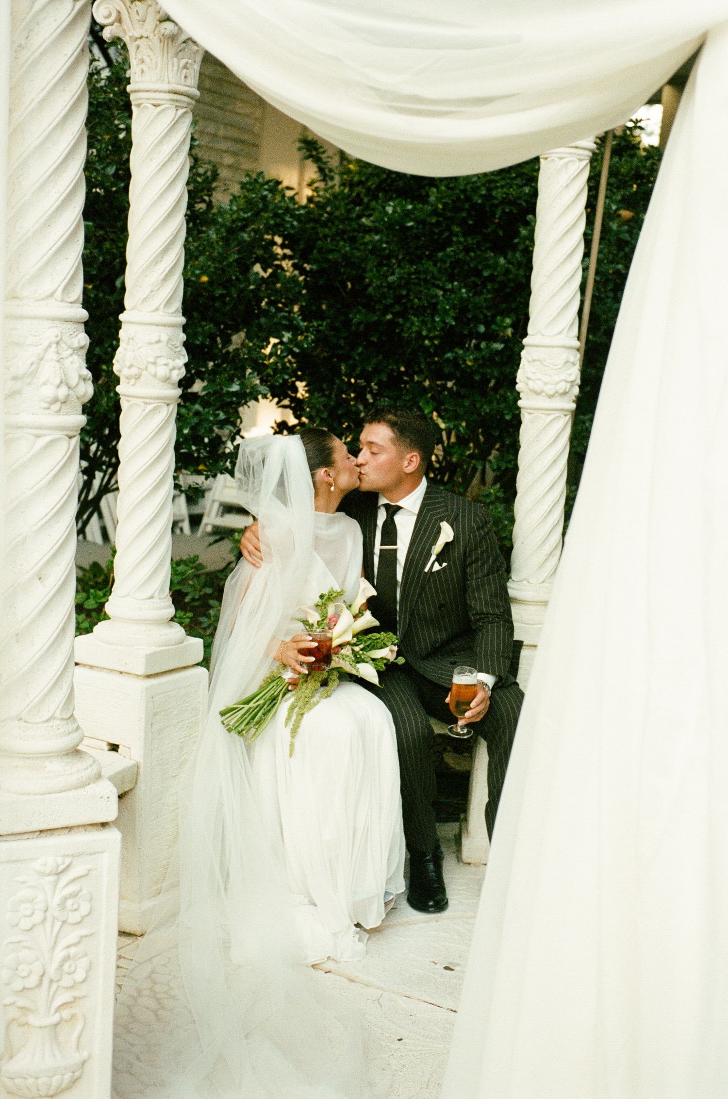 A bride walks down the aisle at the Gastonian with her father, smiling from ear to ear as she looks at her groom