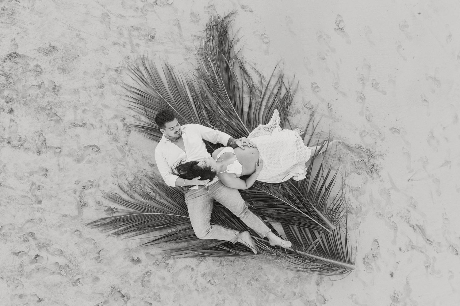 Delicate tropical flowers arranged on palm fronds create an artistic still life in monochrome.