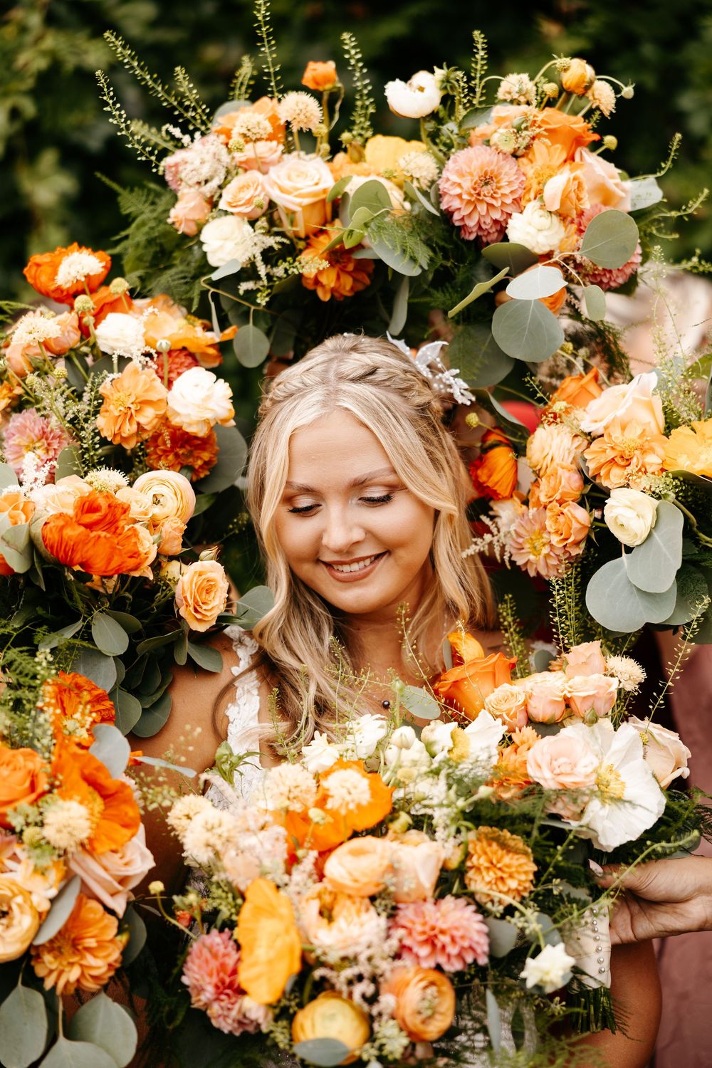 Wedding floral display with orange and peach roses, carnations, and greenery creates romantic setting.