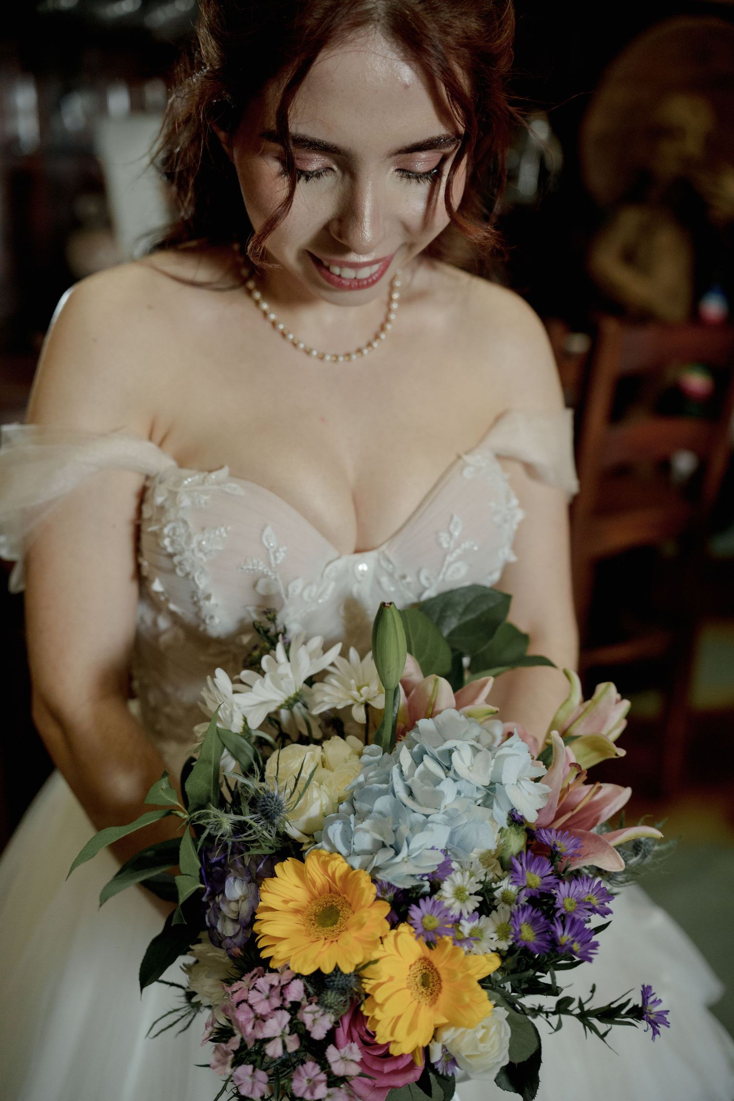 Colorful wedding bouquet featuring yellow gerbera daisies, purple flowers, and greenery.