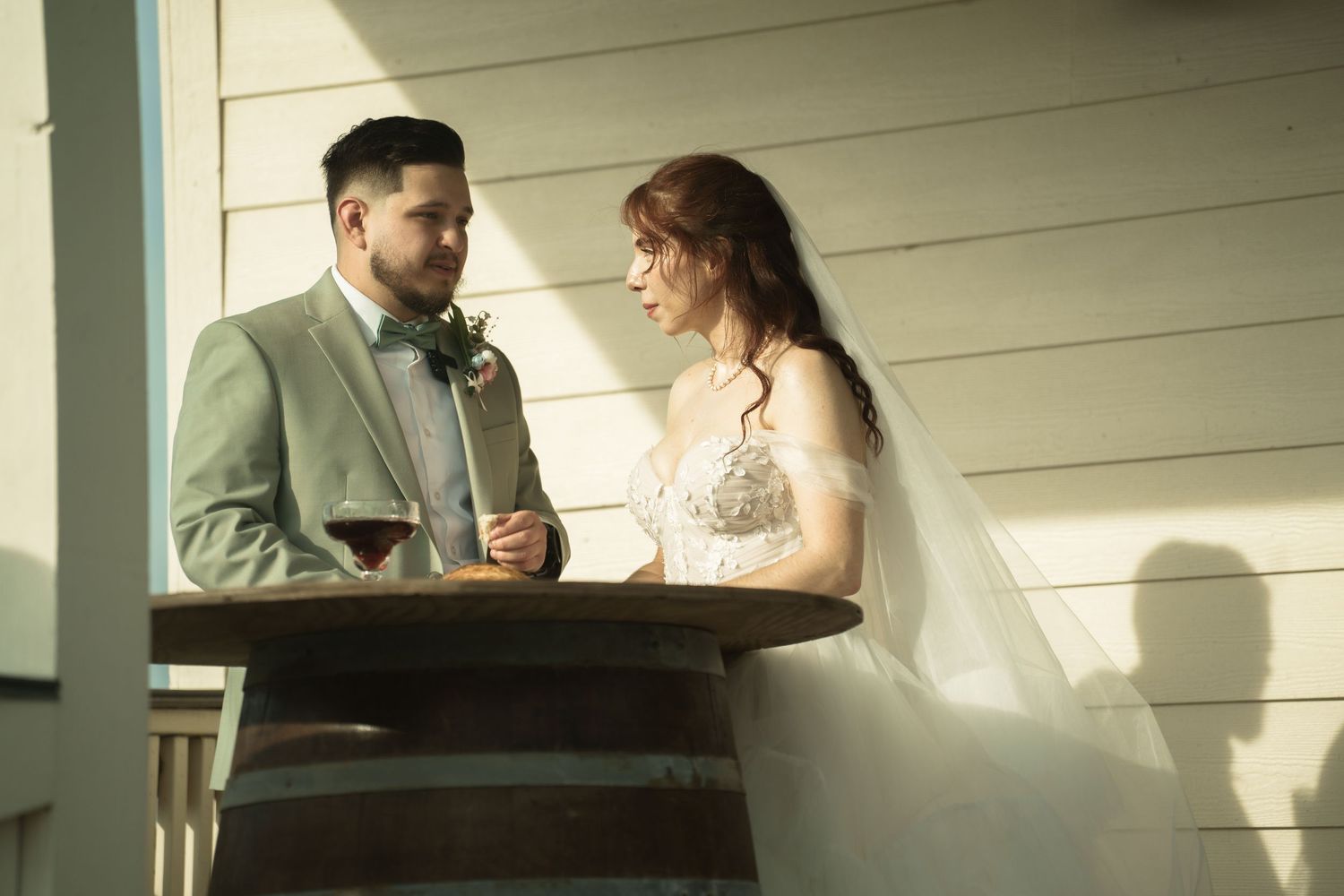 Romantic wedding moment captured on a white porch during golden hour.