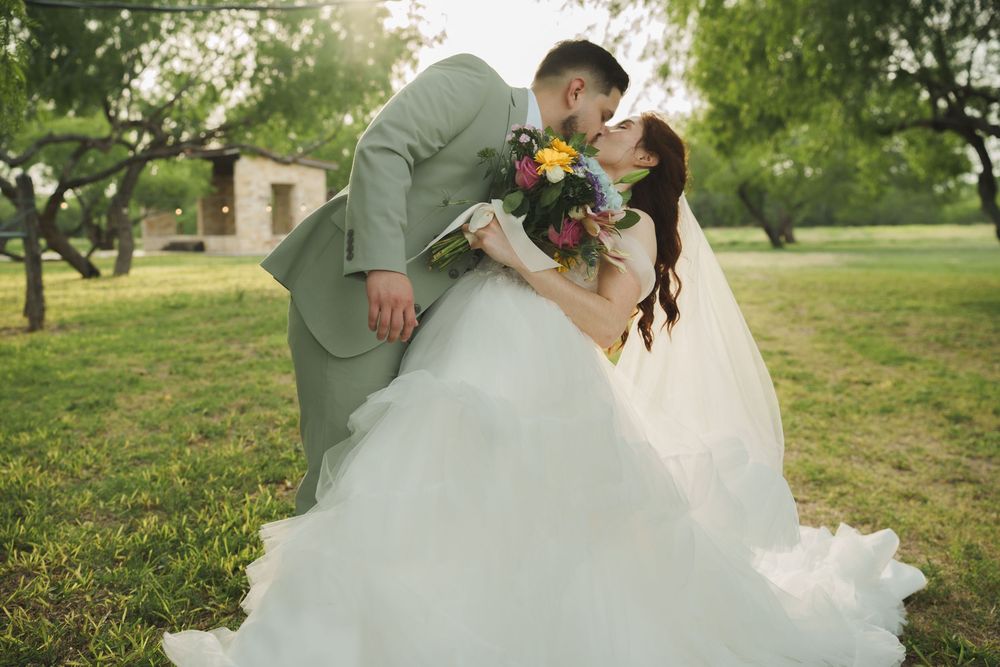 Wedding couple shares joyful moments in a sunlit garden setting.