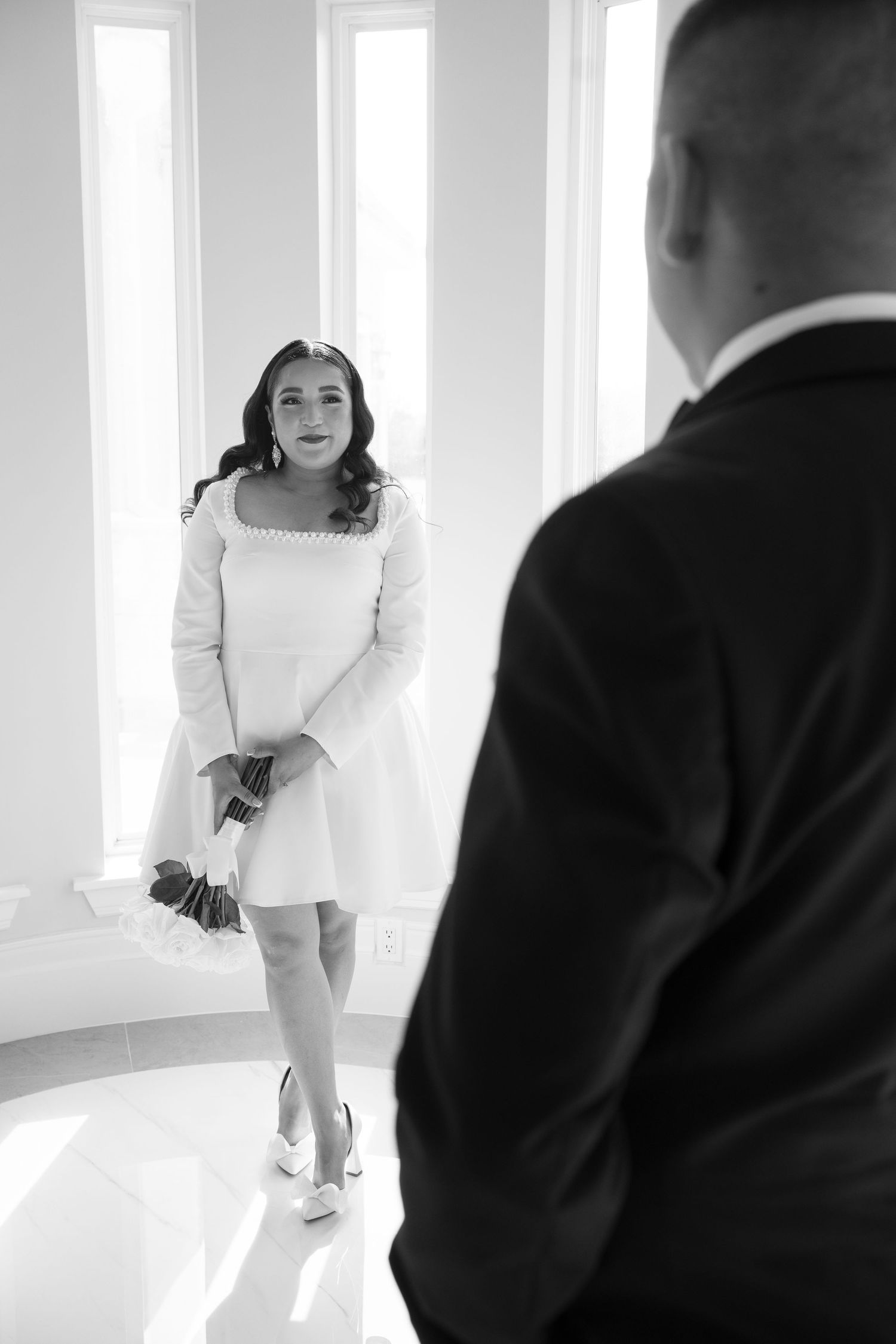 Wedding photography session in a minimalist white room with natural lighting.