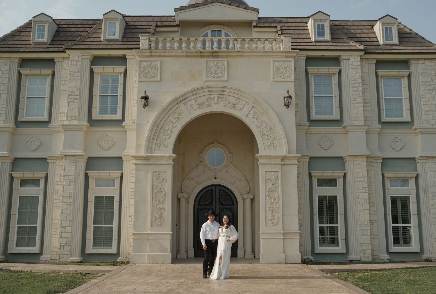 Exterior view of a grand mansion with classical architecture and dormer windows.