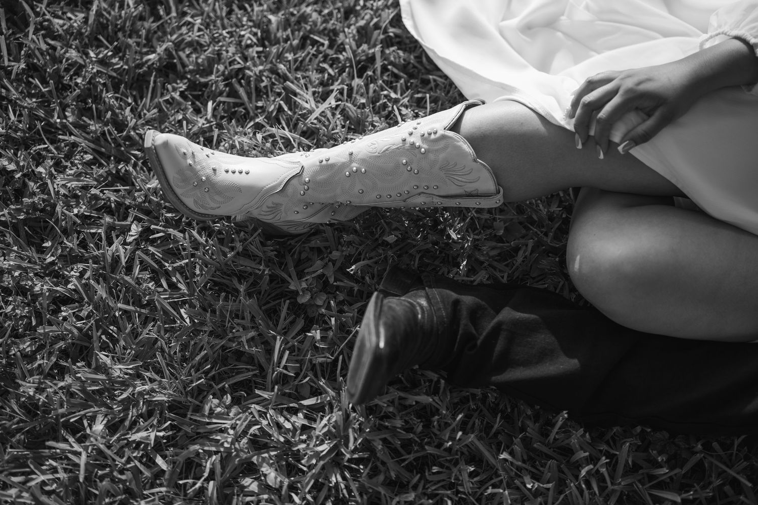 Black and white detail shot of fabric flowing on grass.