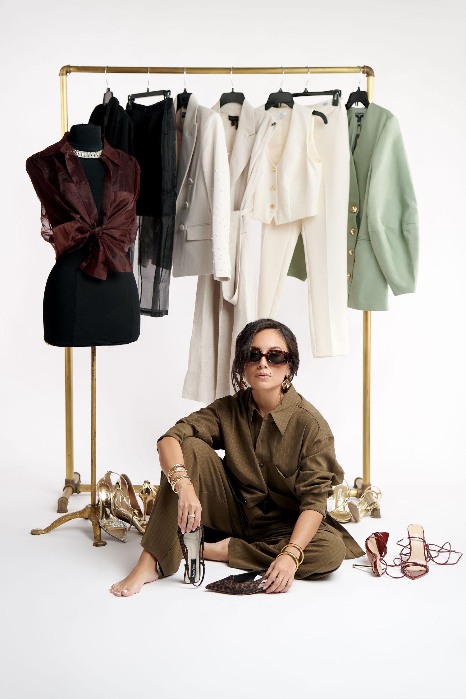 Fashion clothing rack display with draped clothing in earth tones and neutral colors shown from multiple angles.