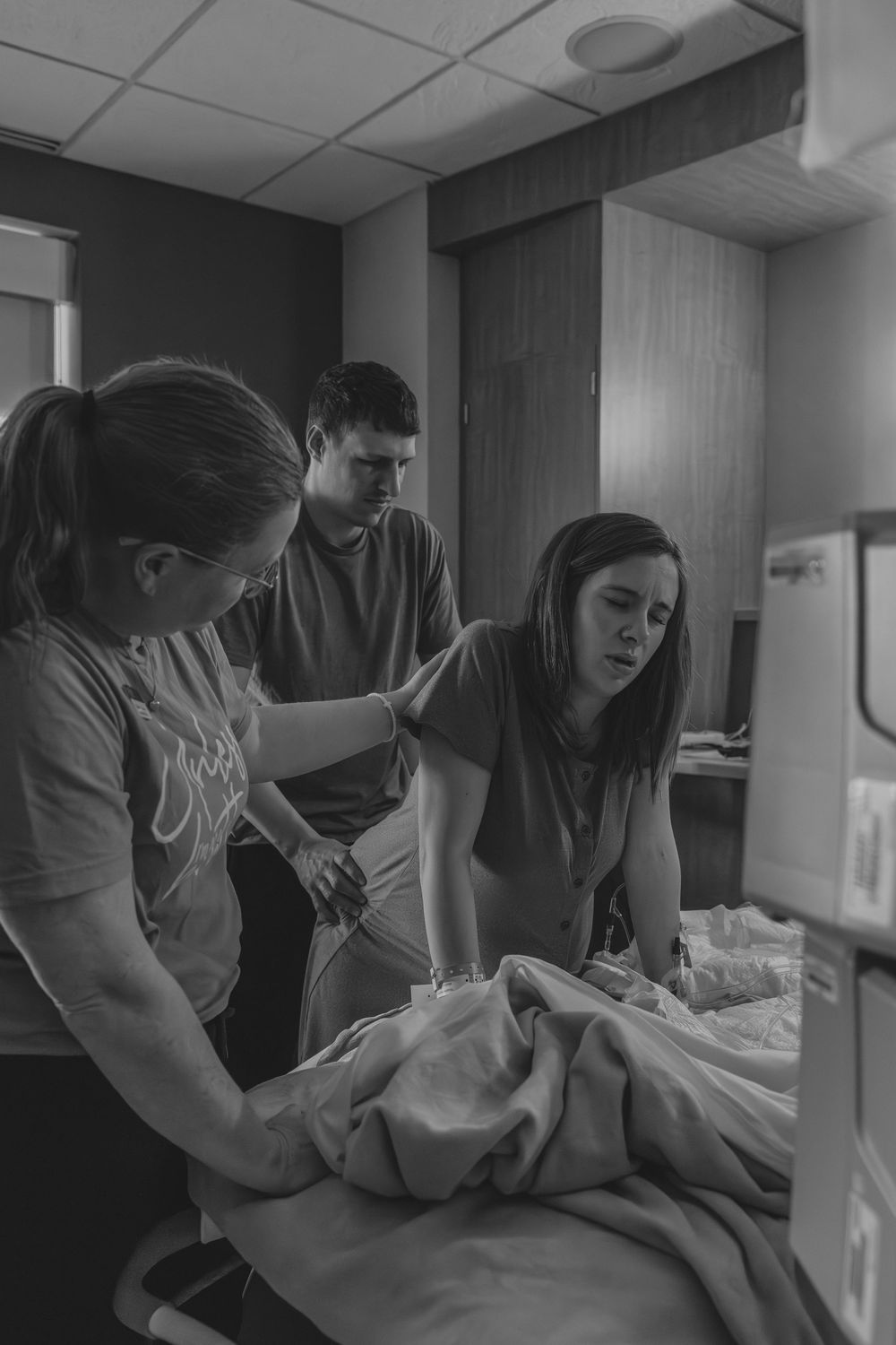 Medical staff attending to patient in hospital room.