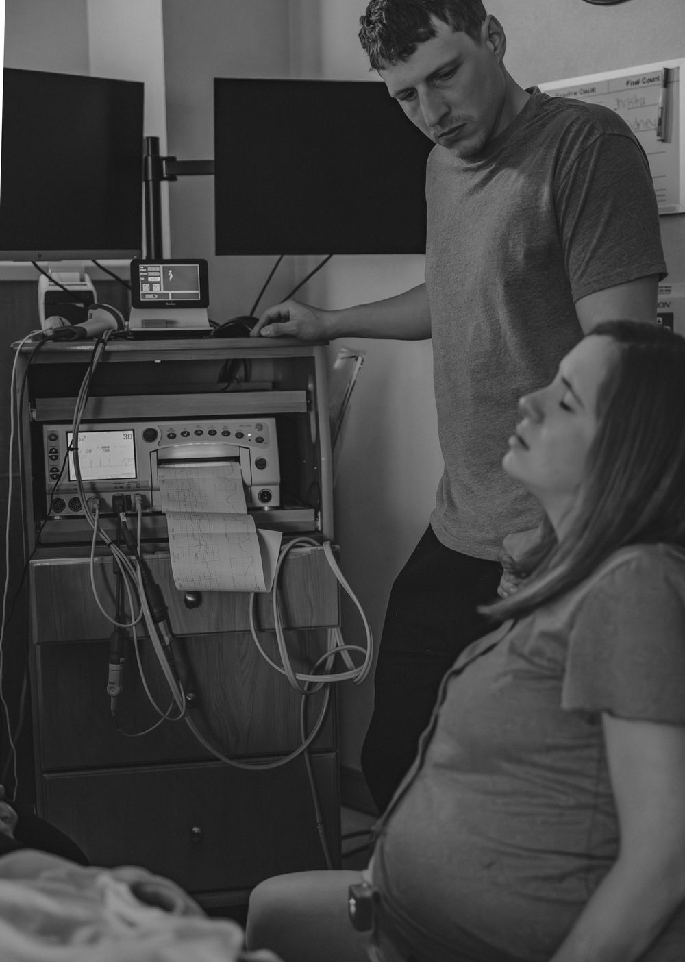 Medical staff monitoring vital signs during labor in a hospital birthing room.