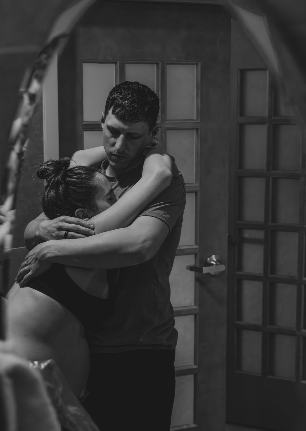 Two people practicing martial arts grappling techniques in a dimly lit studio setting.