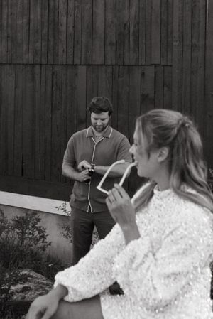 Black and white candid moment outside rustic barn setting.