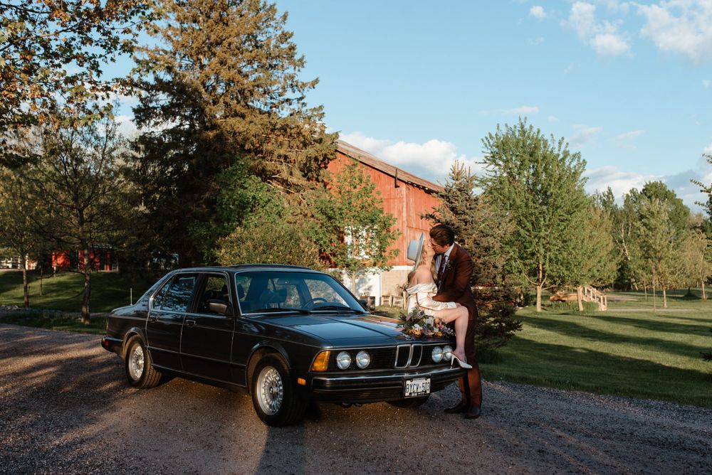 Classic BMW E23 sedan featured in outdoor wedding photography scene.