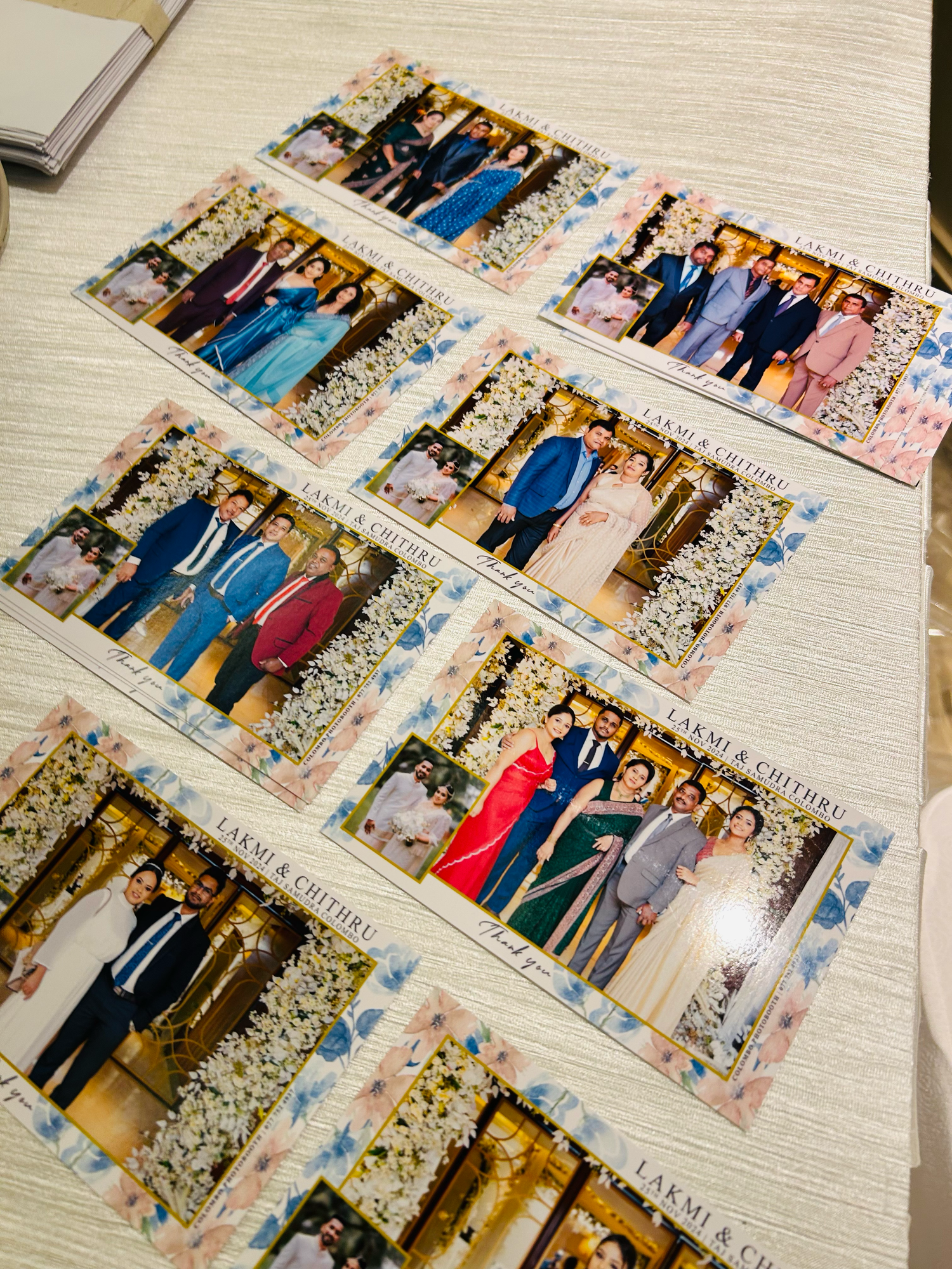 Wedding photo prints laid out in rows showing formal group shots and celebrations.