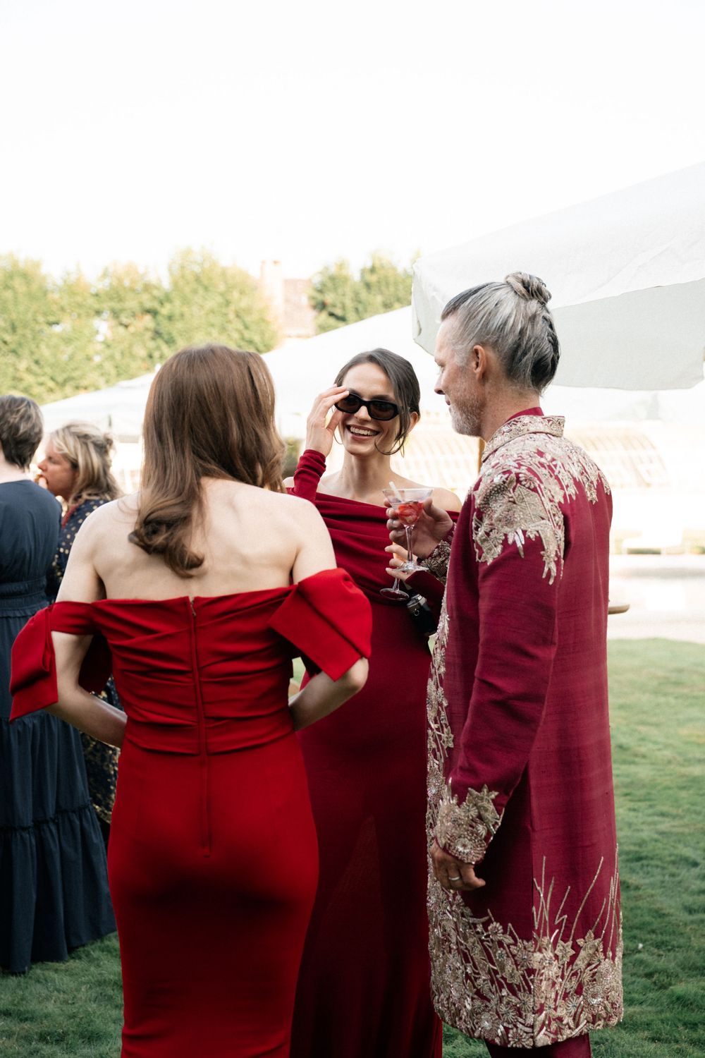 Group wearing red formal attire standing together at an outdoor event.