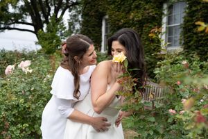 Editorial Image of lesbian wedding couple kissing with trees behind them