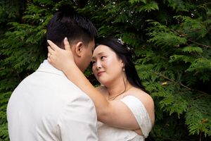 Editorial Image of asian wedding couple kissing with trees behind them