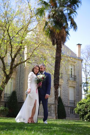 Pareja recién casada sonriendo mientras camina por un sendero natural