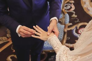 Novio colocando el anillo en el dedo de la novia.