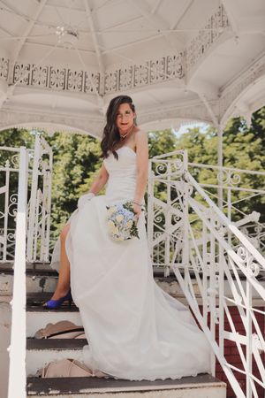 Novia en escalera de gazebo blanco con ramo azul y zapatos altos azules, Vitoria-Gasteiz, Alava