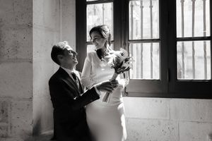 Novios en atuendo formal junto a ventana con luz natural, en interior de arquitectura histórica, fotógrafo boda en Burgos