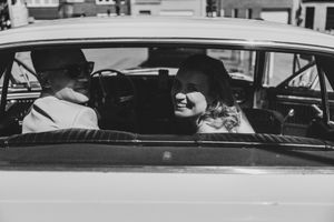 Tijdloze huwelijksfoto in zwart wit van een koppel in hun klassieke auto, reportage in Niel door Bart Boodts Photography.