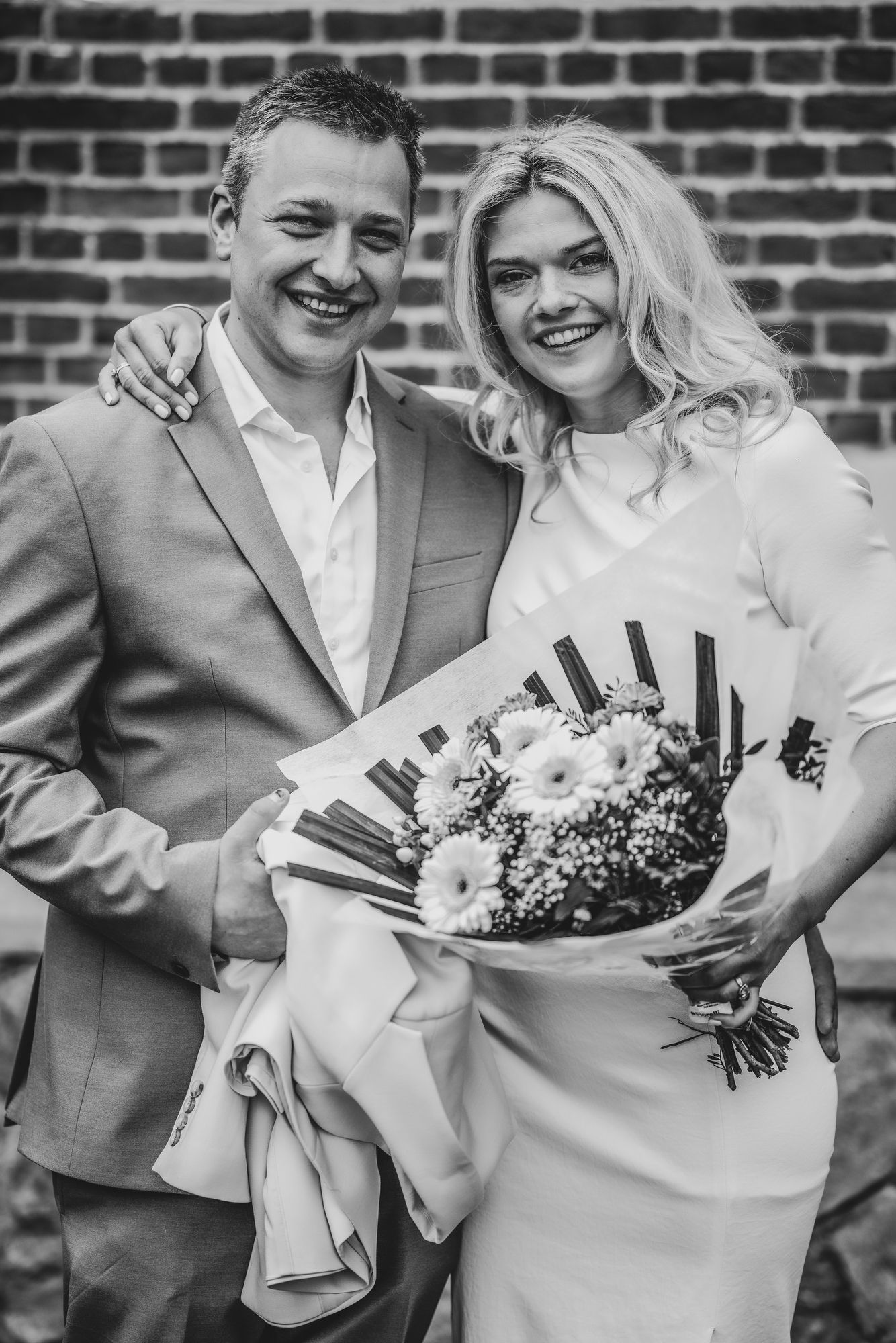 Stijlvol koppel poseert met boeket tijdens hun huwelijk in Niel, fotografie door Bart Boodts Photography.