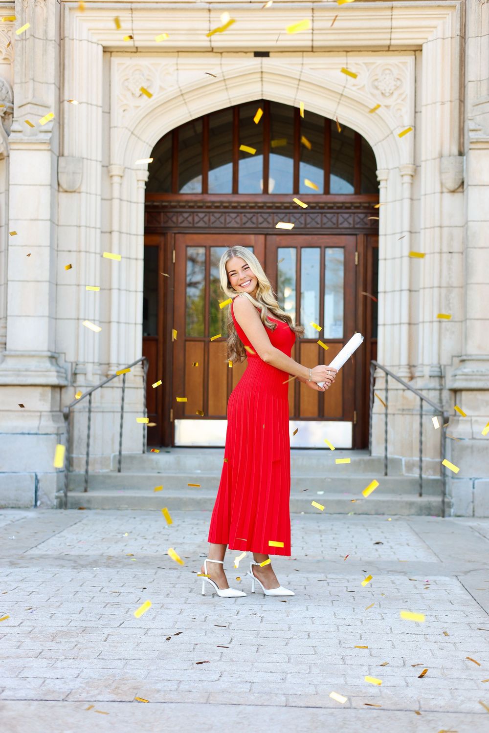A series of photos showing someone in a flowing red dress twirling and dancing in front of a grand stone building entrance.
