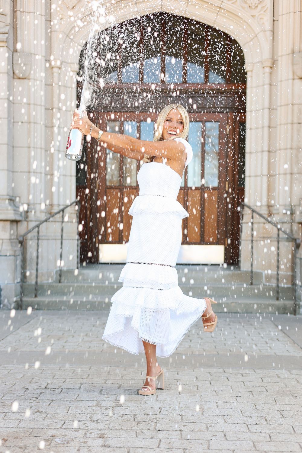 A sequence of joyful moments captured in a white dress with falling confetti against a stone building backdrop.