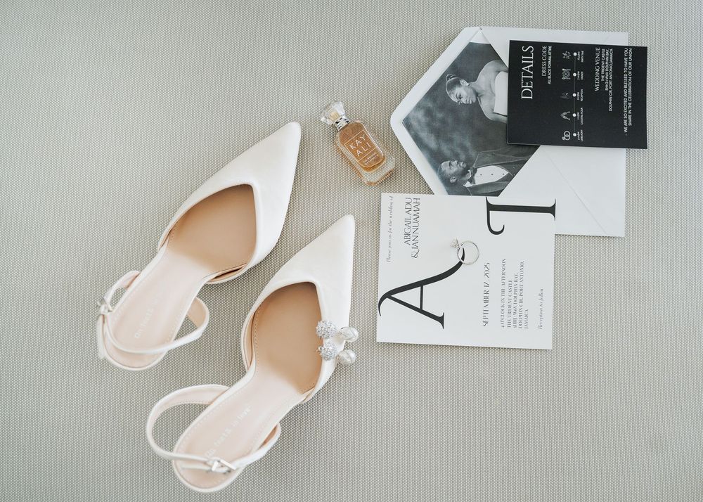Elegant white slingback wedding shoes with crystal embellishments displayed on a light gray background.
