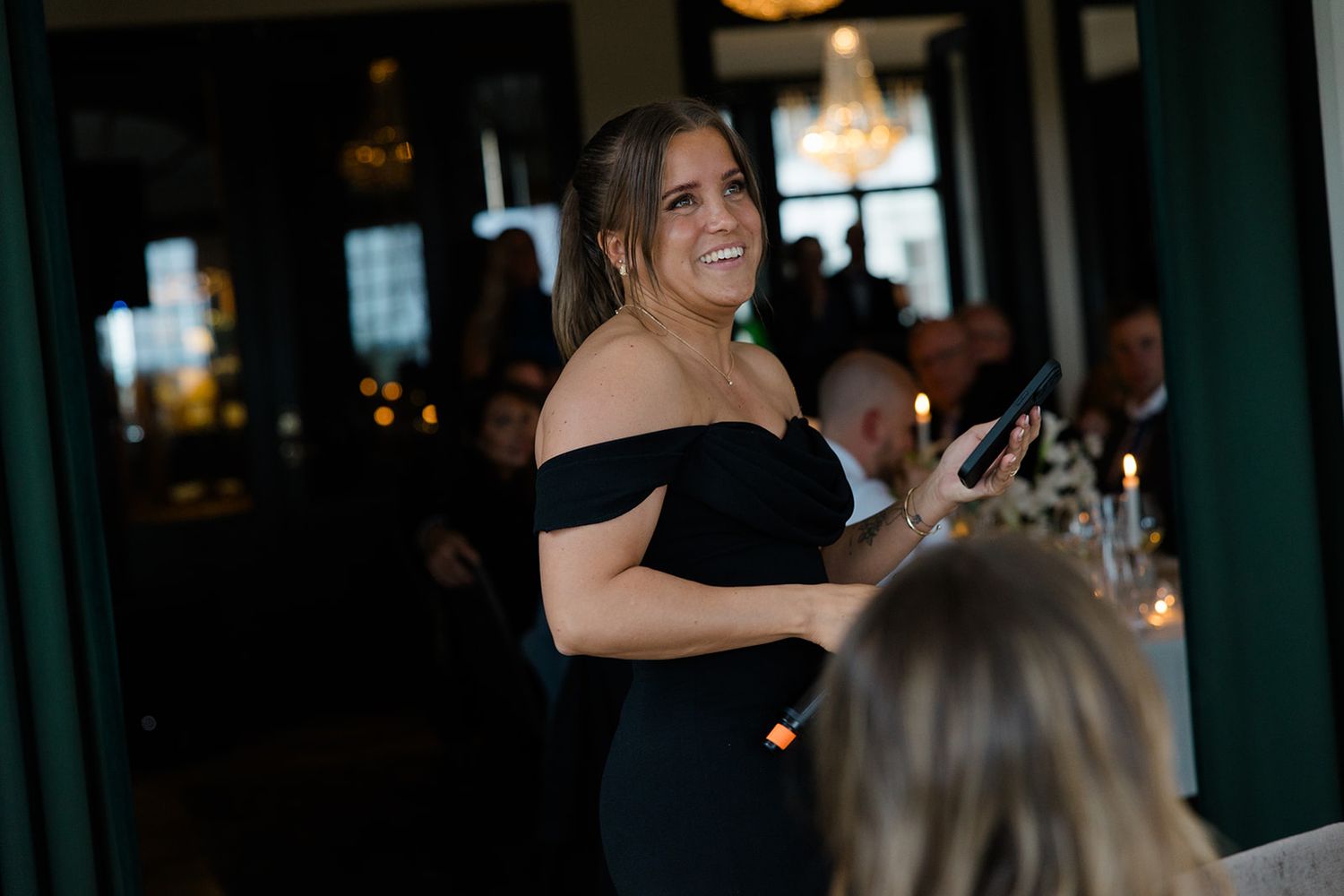 People celebrating and socializing at an elegant indoor event with drinks and formal attire.