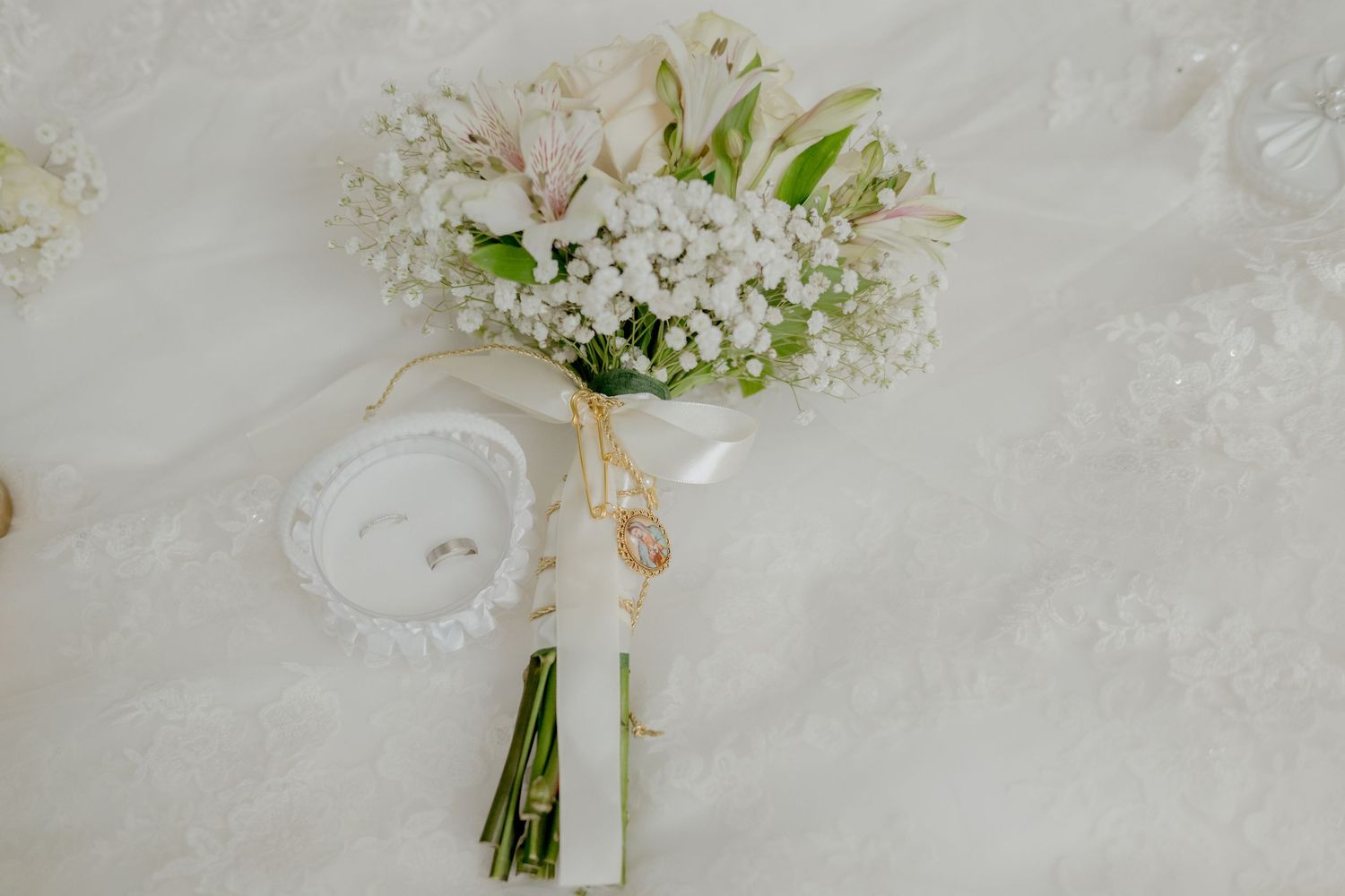 White floral wedding bouquet with delicate baby's breath flowers tied with a white ribbon.