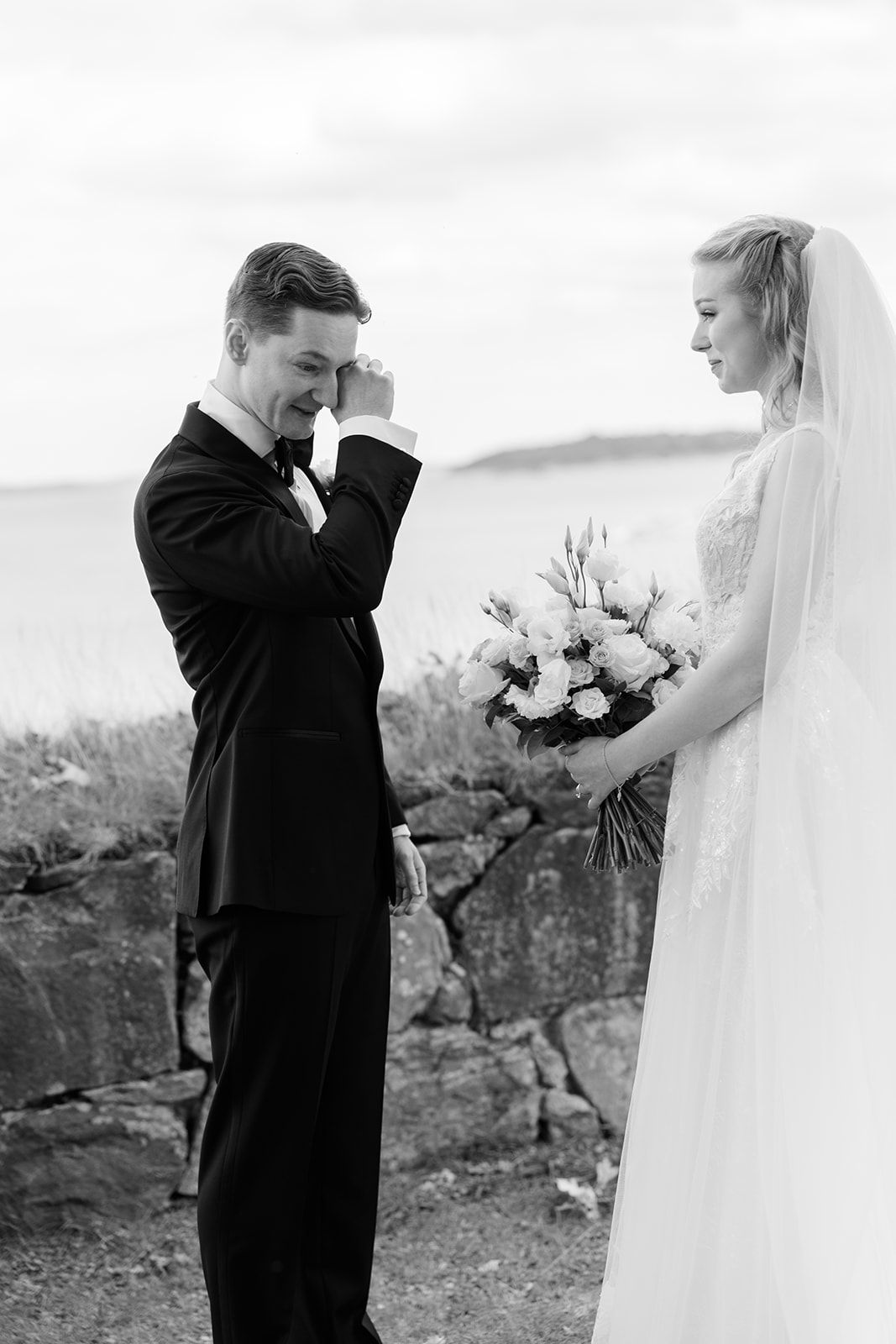 A series of black and white wedding photos showing an emotional first look moment between the couple.