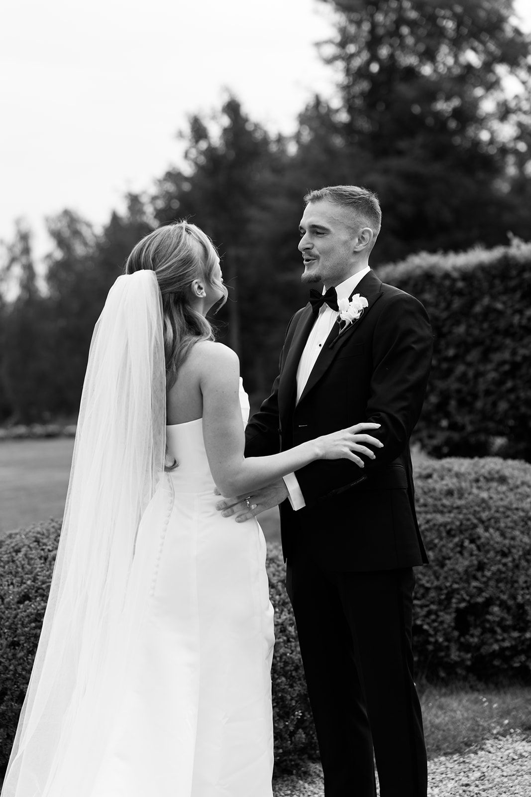 A romantic black and white wedding photo series showing tender moments between a bride and groom outdoors.