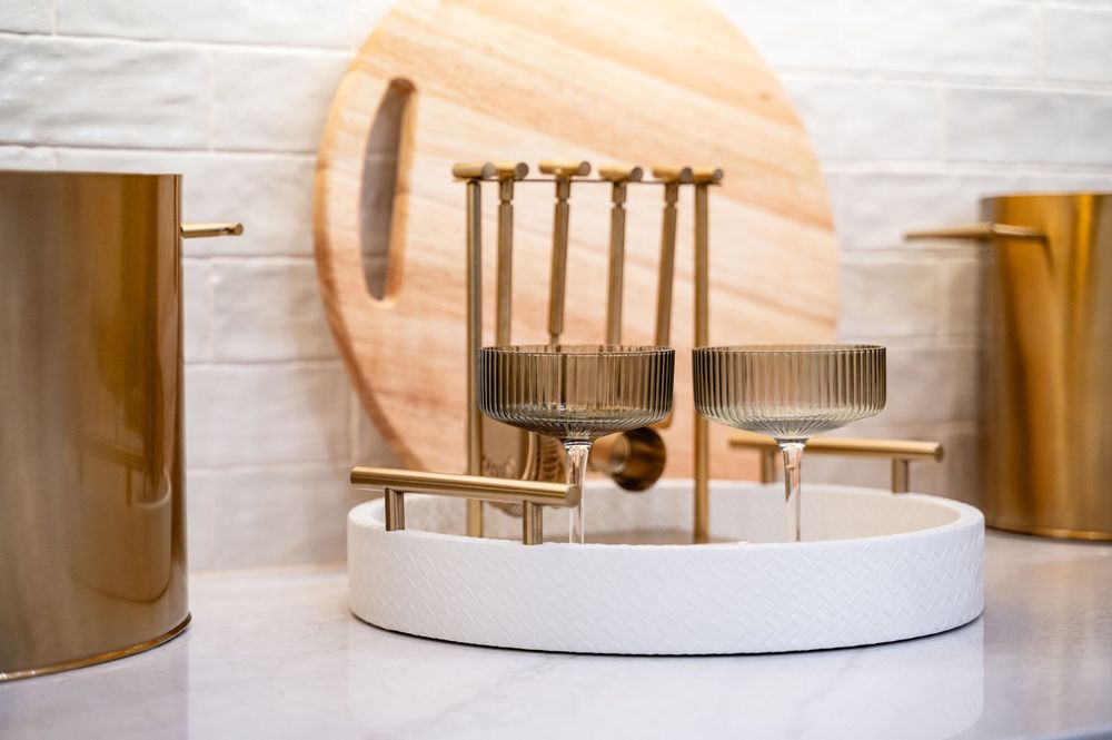 Modern white and gold bathroom with round mirror, sleek faucet, and contemporary minimalist design details.