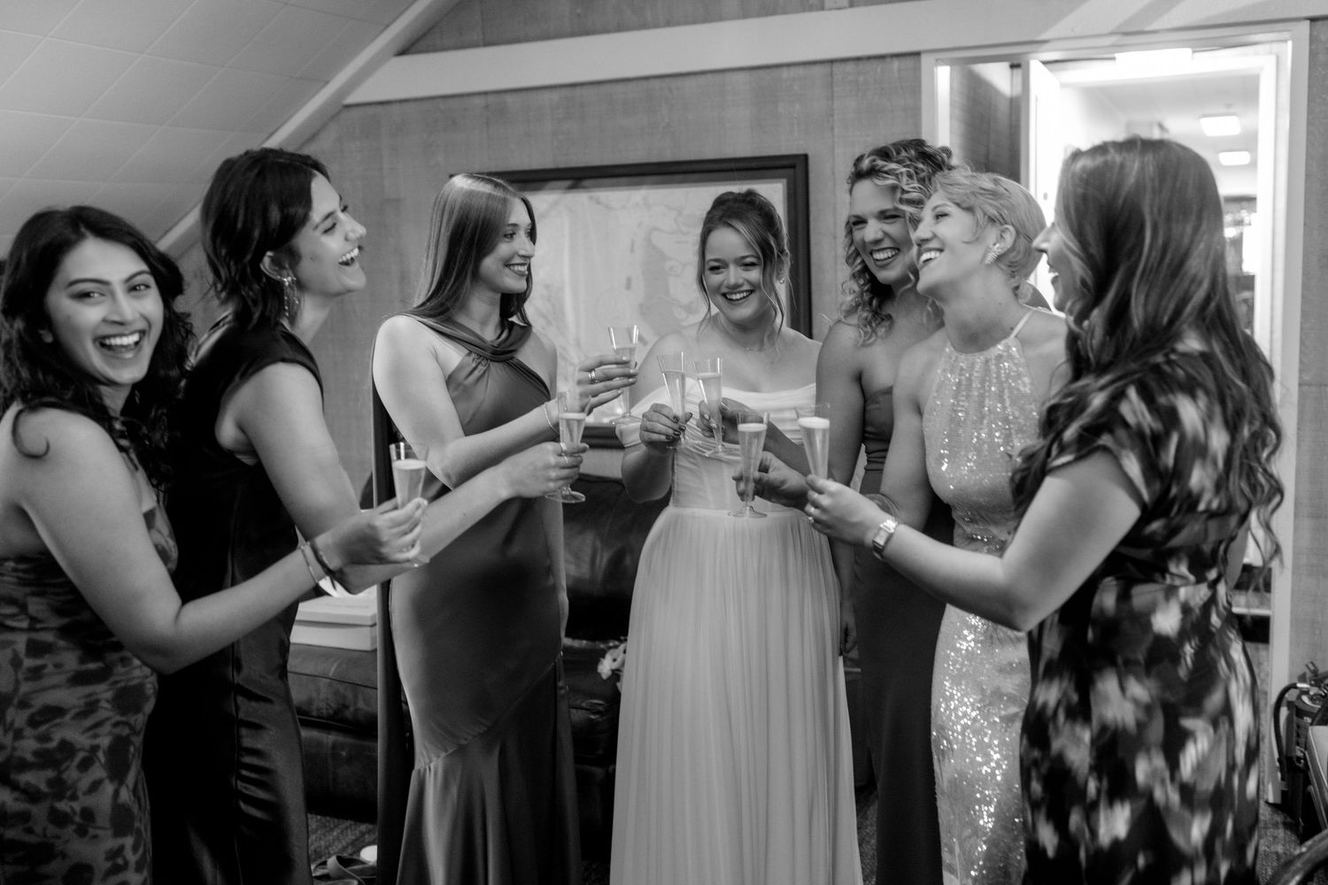 Wedding party guests socializing and toasting during indoor celebration.