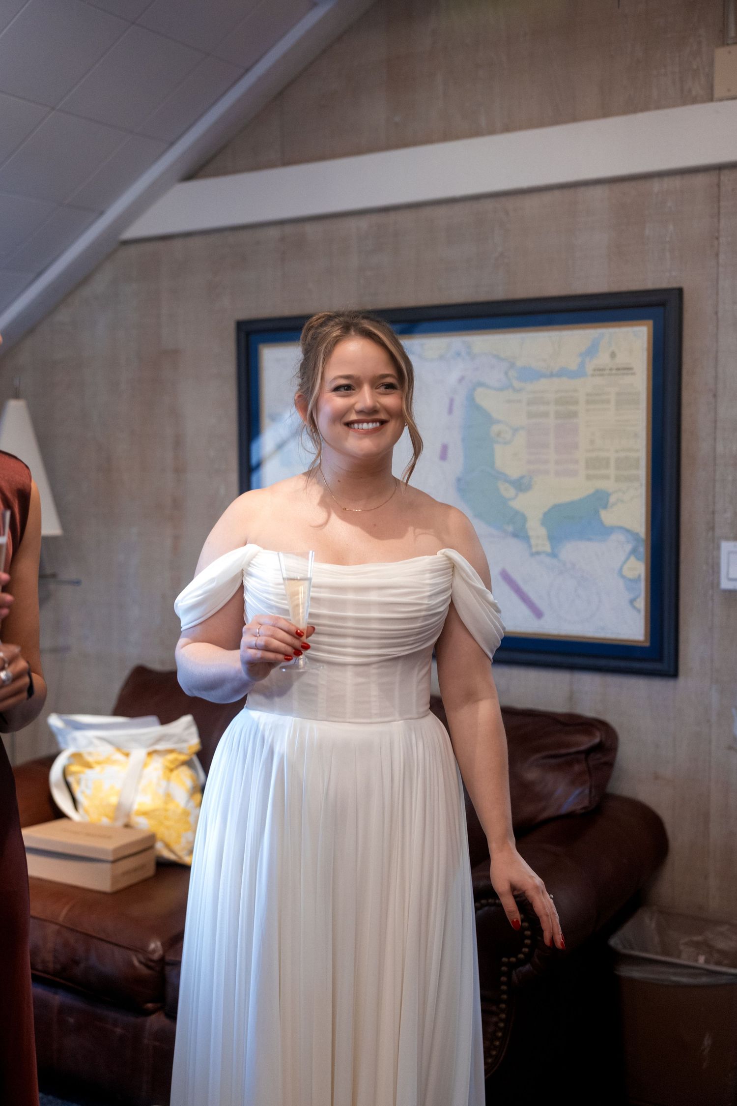 A series of photos showing someone in a flowing white off-shoulder wedding dress indoors.